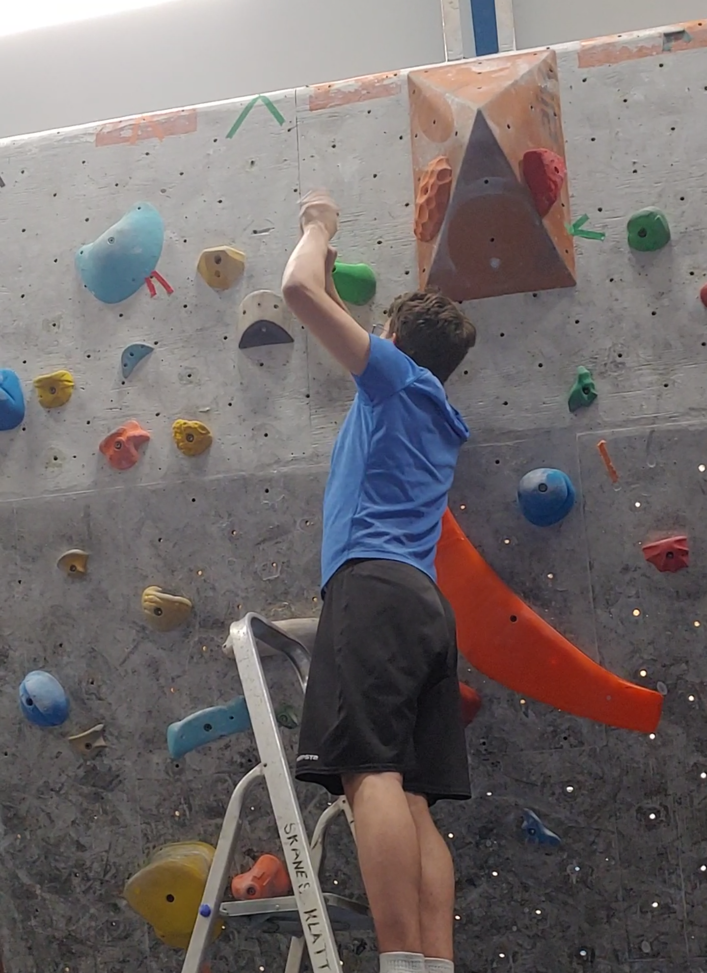 Me drilling a climbing hold into a wall.